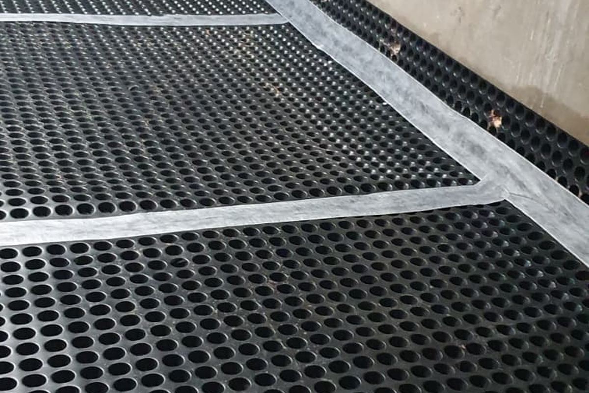 Noppenmembraan over de keldervloer met afgetapete naden voor vloerdrainage door Aqua-Block