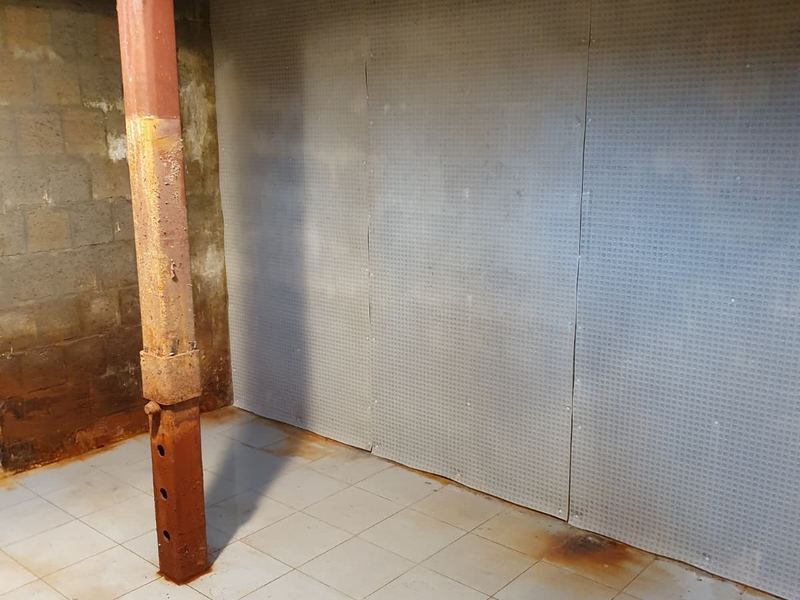 Gecementeerde keldermuur na plaatsing van de drainage, werf van Aqua-Block