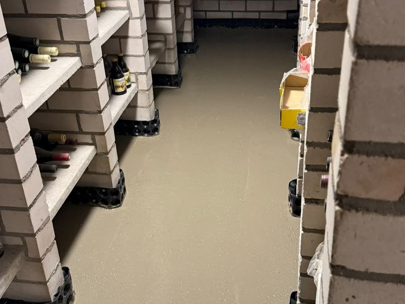 Keldervloer met verse cementlaag over de drainage, werf van Aqua-Block
