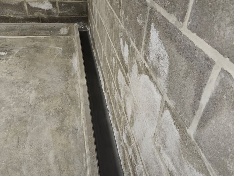 Randdrainage in uitvoering langs de naad tussen muur en vloer, werf van Aqua-Block